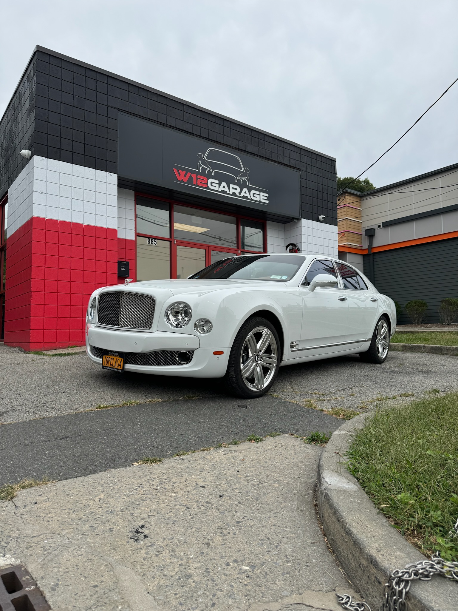White Bentley parked near the front of the W12 Garage entrance